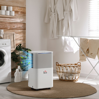White dehumidifier in a laundry room with washing machine, dryer, and laundry items.